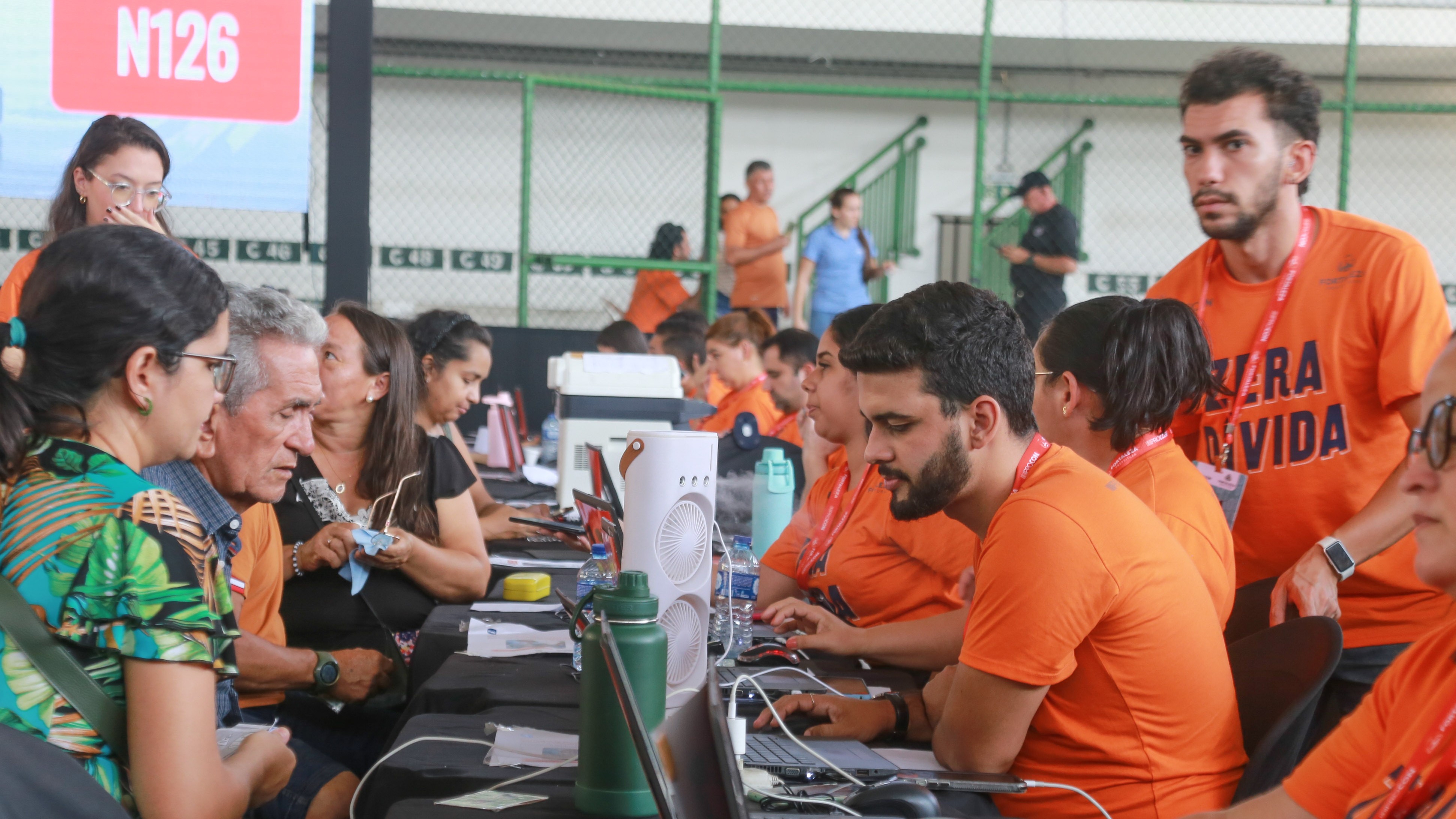 mesas de atendimento do mutirão do procon na quadra de um ginásio